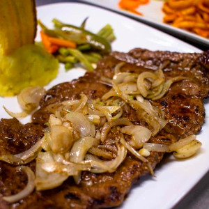 Bistec de cerdo encebollado